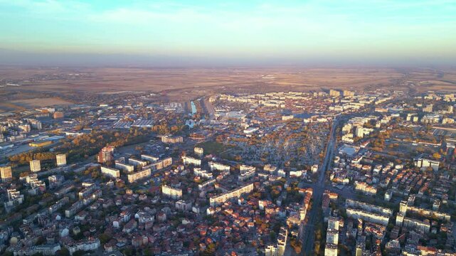 Aerial drone footage of a sunset over the city of Plovdiv in Bulgaria. Ancient city of Filipopolis filmed from above on a warm autumn afternoon. European city seen from a helicopter establishing shot.