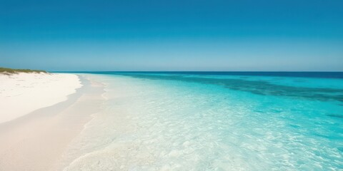 Obraz premium Spectacular sandy shoreline with crystal clear turquoise waters under a bright blue sky, picturesque