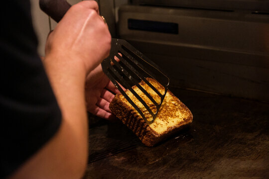 hand holding a spatular making French toast