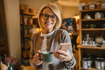 woman entrepreneur use mobile phone and drink coffee at rustic shop