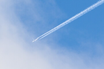 Transport airplane makes the very strong trace line of chemtrails on blue sky. Conspiracy theory.
