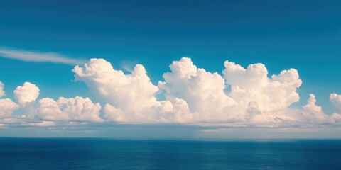 Fototapeta premium A sprawling expanse of fluffy white clouds cast their shadows over the vast blue ocean, creating a serene and awe-inspiring seascape.