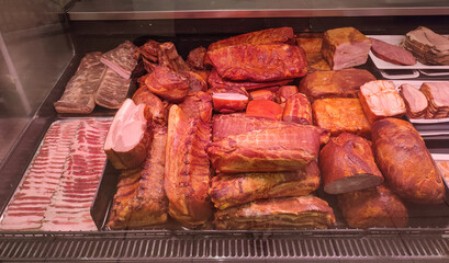 A counter with various types of smoked meat products