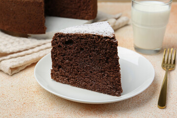 Piece of tasty chocolate sponge cake served on light table, closeup