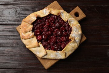 Tasty galette with cherries on wooden table, top view