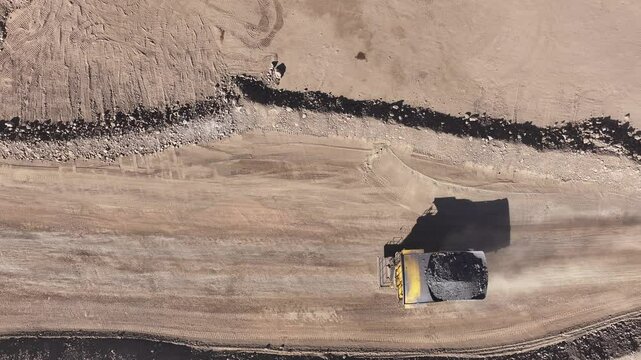 Loaded Mining Trucks Advancing Through an Open-Pit Copper Mine in Chile - High-Tonnage Mineral Transportation in a Rugged Mining Landscape