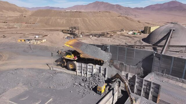 Aerial View of a High-Tonnage Mining Truck Unloading Copper Ore at a Primary Crusher in Chile - Industrial Operations in an Open-Pit Mine