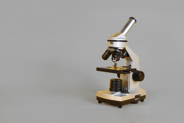 A microscope  on a grey background