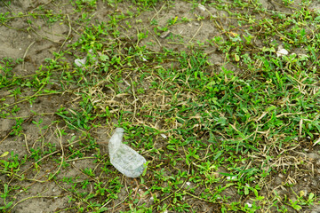 A plastic bottle over a green natural background. contamination concept.
