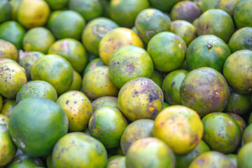 Stacks of freshly harvested Sweet Oranges are displayed at a traditional Indonesian market for sale