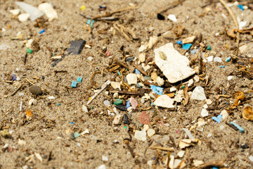 Microplastics on beach sand. Climate change and ocean pollution.