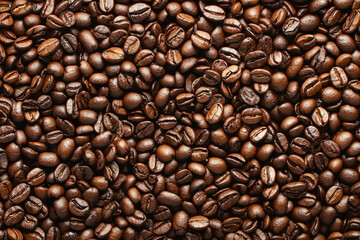 Obraz premium Freshly roasted coffee beans spread across a wooden surface