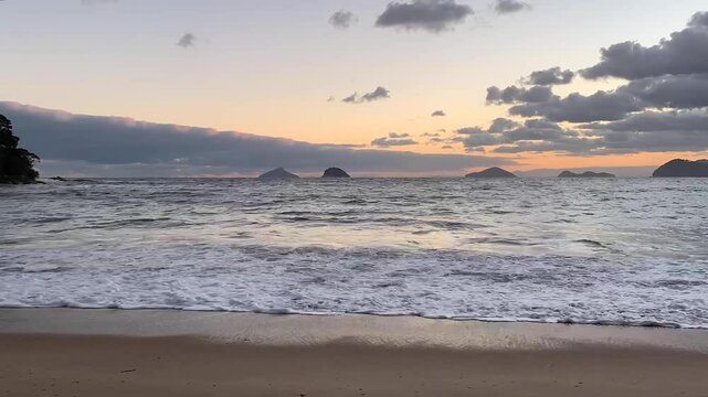 Time-lapse ressaca forte do mar em tarde com nuvens cobrindo o p&ocirc;r do sol. Ao fundo, quatro ilhas bem famosas do litoral norte:  Ilha Mont&atilde;o de Trigo, Ilha dos Gatos, Ilha das Couves e Ilha As Ilhas. 