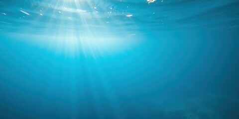 Obraz premium Sunlight Beams Through the Tranquil Blue Depths of the Ocean, Casting a Mystical Glow on the Underwater World