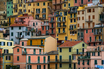 Fototapeta premium Vibrant facades of Cinque Terre houses stacked against hillside. Famous Italian village known for colorful architecture and scenic beauty.