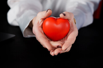 A Compassionate Gesture: Hands Cradling a Red Heart Symbolizing Love and Care