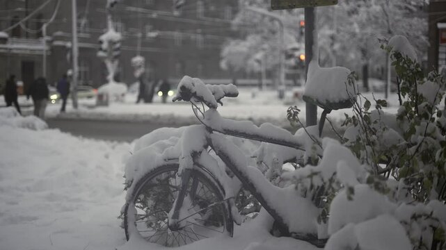 Munich, Germany. Snowfall in Muenchen. Snow covered bicycles in city parking lot. Snow drifts and bikes in snow in a parking area. Schneeeinbruch in Munchen, Deutschland. 