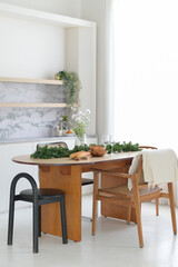 Modern dining table with wooden chairs and greenery decor