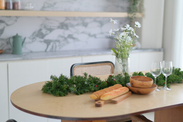 Festive dining table with bread, greenery, and flowers