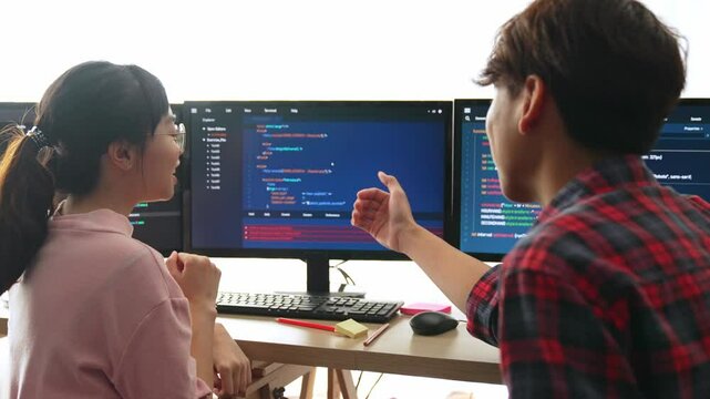 Slow motion back end software developer engineer for computer programming working together on debugging writing computing code, solving complex algorithms display on monitor in office. Burgeoning