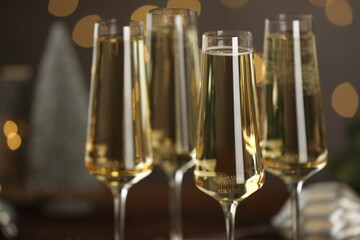 Champagne in glasses and decor on dark background blurred Christmas lights, closeup. Bokeh effect