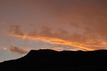 Mountain ridge at sunset, with orange clouds