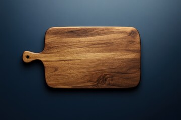 Rectangular wooden cutting board with handle on dark background.
