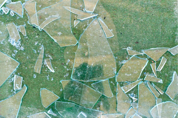 Shards broken pieces of glass on green surface, broken glass