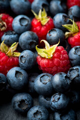 Ripe blueberries and raspberries. Selective focus. Shallow depth of field. Background and textures.