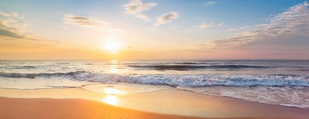 Obraz premium Golden hour paints the sky with vibrant hues as the sun dips below the horizon, casting its warm glow over the tranquil ocean and sandy shores
