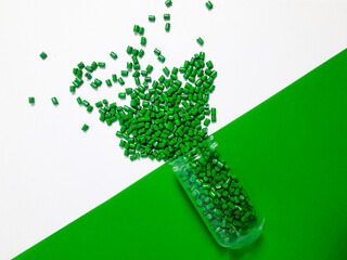Green masterbatch granules with glass tube on white and green background,color pigment carrier...