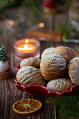 Cookies in the shape of cones with Christmas lights and pine on the wooden table