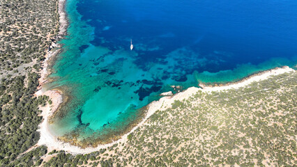 Aerial drone photo from tropical exotic paradise secluded rocky island bay with deep turquoise sea forming a blue lagoon visited by yachts and sail boats in Caribbean exotic destination