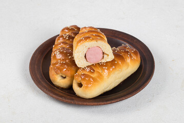 Hot sausage in the dough. Hot dog. On a plate.