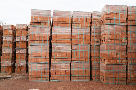 Pallet of clay bricks in warehouse, clay bricks stored for building construction, pallets with bricks in building warehouse.