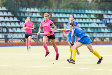 Female field hockey players in attack on the pitch