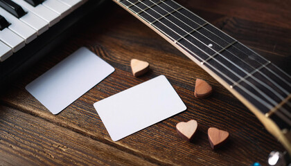 Fototapeta premium Business card mock up on wooden surface accompanied by guitar and sheet music with decorative wooden hearts