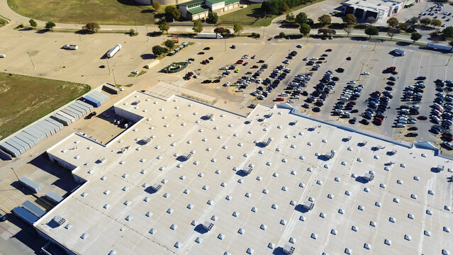 Full parking at entrance of large grocery store with commercial rooftop and packaged units RTU on flat roof, HVAC conditioning cooling, dehumidifying, heating, heat pump and air handlers, aerial