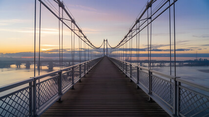 Fototapeta premium Symmetrical view of a suspension bridge at sunrise.