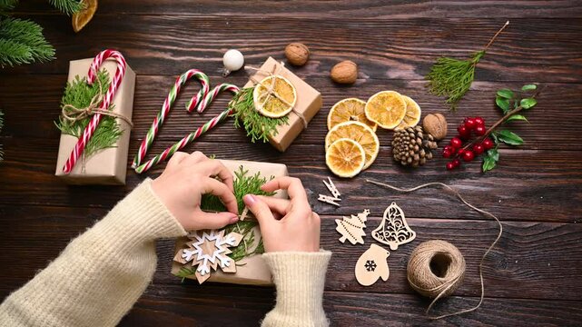 Sustainable christmas. Female hands are packaging christmas gifts on craft paper. Eco Christmas holiday concept. Zero waste, eco friendly.