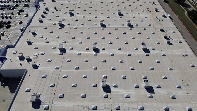 Full parking at entrance of large grocery store with commercial rooftop and packaged units RTU on flat roof, HVAC conditioning cooling, dehumidifying, heating, heat pump and air handlers, flyover