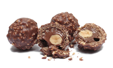 Chocolate balls and half with hazelnut isolated on white, top view