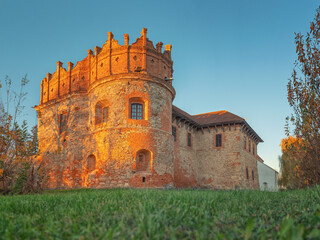 view from door point to grass meadow and crown shape brick tower of old castle in sunset time