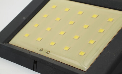 A white LED that forms a matrix on a white background. A row of LEDs (Light Emitting Diodes) that form an array with a number of columns and rows. Usually to light up a road or room.