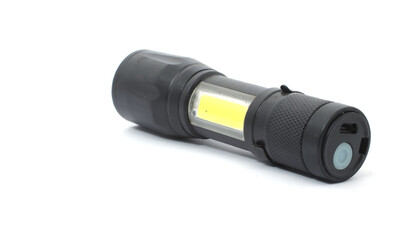 The side of a black handheld flashlight with a yellow led and a push button on a white background.