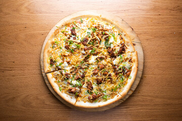 BBQ Chicken Pizza topped with tender chicken, melted cheese, and fresh herbs served on wooden board isolated on table background top view of italian cousin