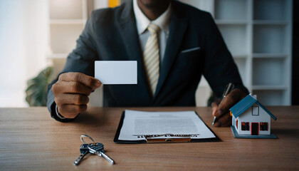 Business card mockup with keys and house model on a desk, illustrating real estate services in a professional setting