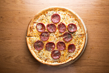 Classic Pepperoni Pizza topped tomato sauce, melted mozzarella cheese served on wooden board isolated on table background top view of italian cousin