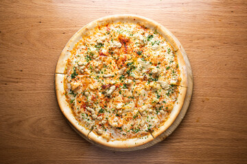 Creamy Chicken Pizza topped tender chicken, and a creamy white sauce served on wooden board isolated on table background top view of italian cousin