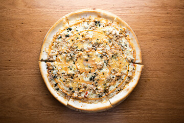 Spicy Korean BBQ Pizza topped with tender Korean BBQ chicken, melted cheese served on wooden board isolated on table background top view of italian cousin